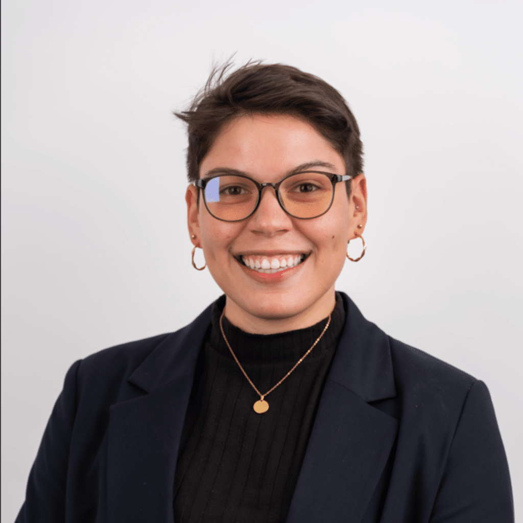 Natlie in a black suit jacket and sweater underneath.