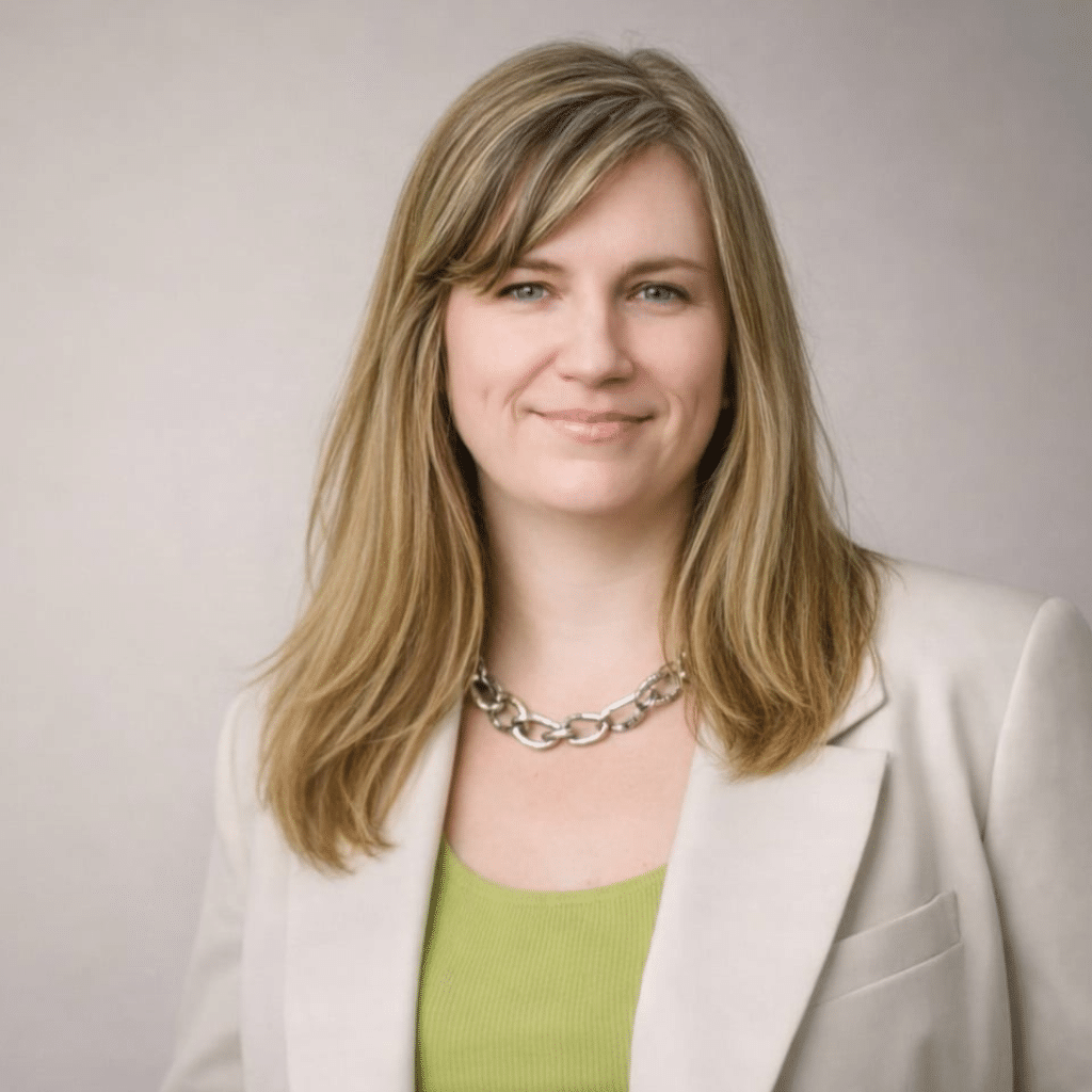 Rebekka in a light suit jacket and green shirt.