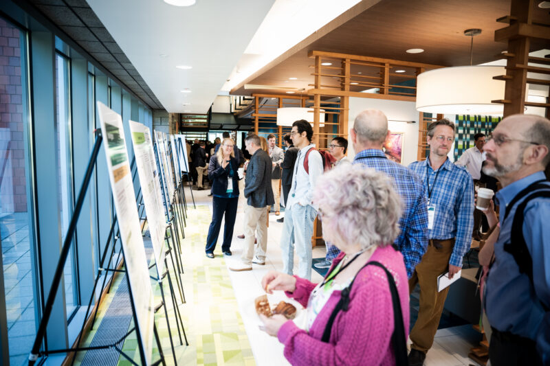 People wearing name badges look at posters in the lobby of the Innovation Space.
