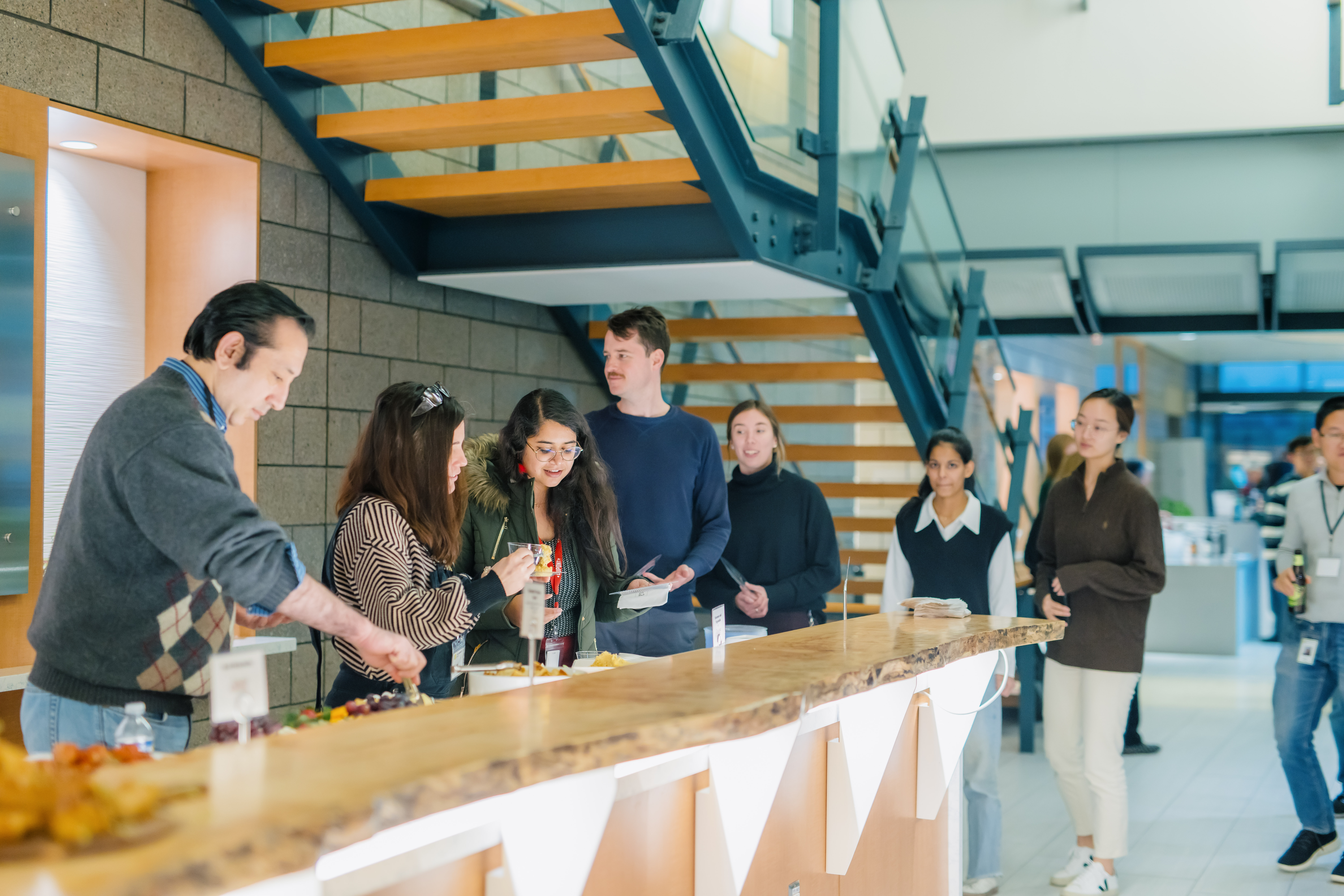 People in the lobby of the Innovation Space standing in a line to get food and drinks